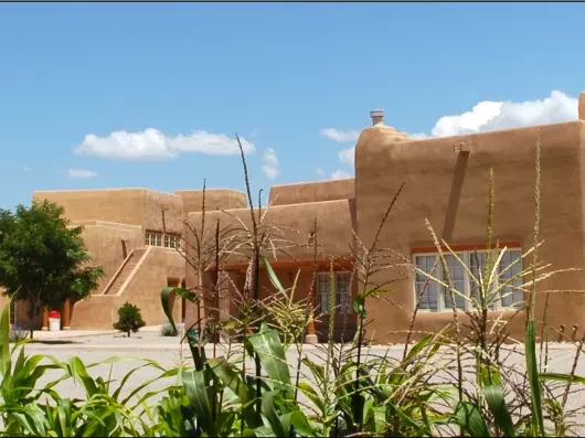 An adobe-style school building against a blue sky