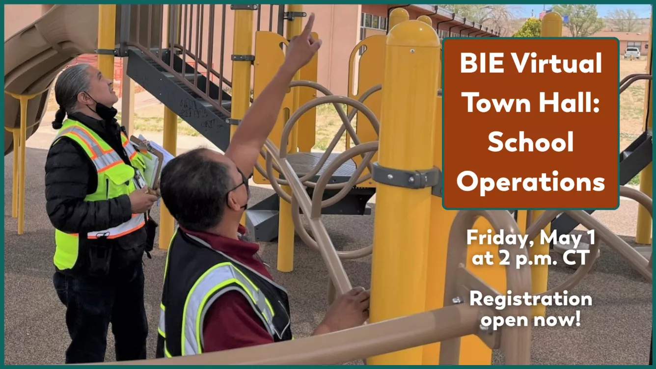 Two workers in safety vests inspect a colorful playground.