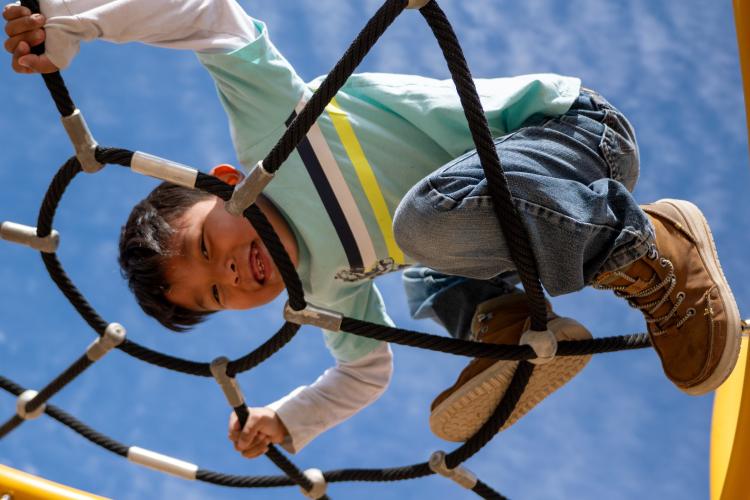 A child climbs on a jungle gym.
