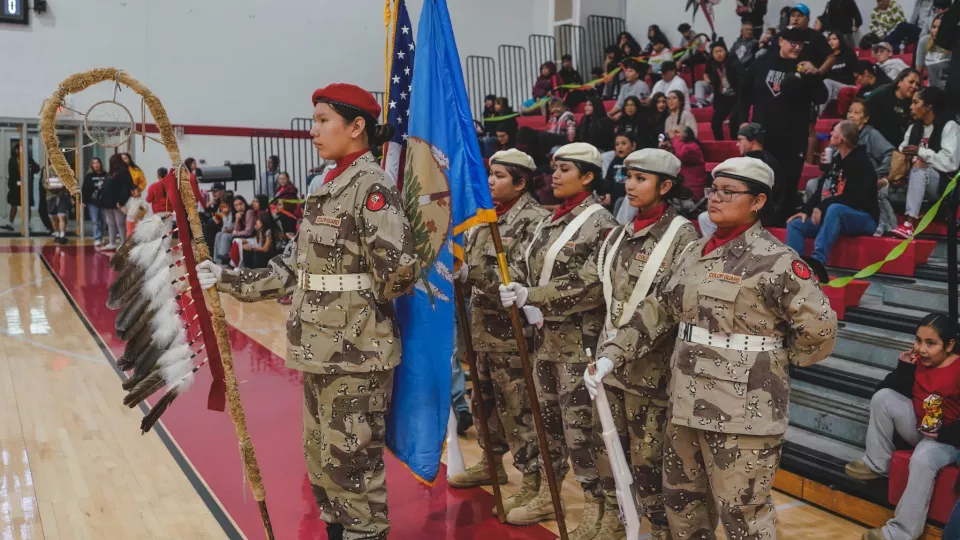 The Riverside Indian School Color Guard from Anadarko, Oklahoma, presents the colors at a sporting event.