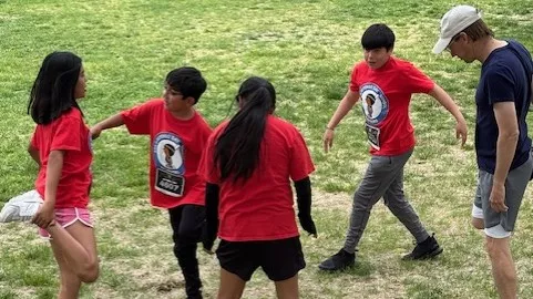  A group of students and their counselor stretch before running.