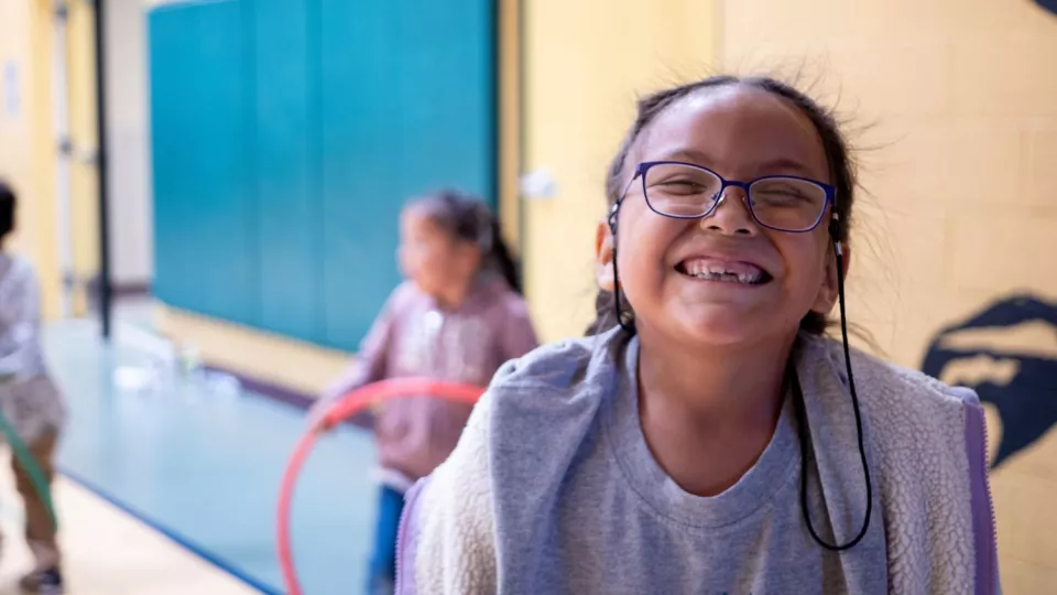 A female student wearing glasses smiles for the camera.